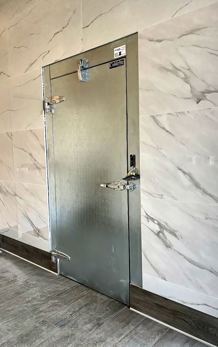 Custom Coldrite walk-in door set in a marble-finish wall